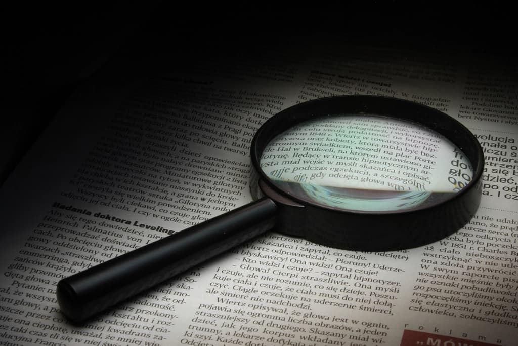 A magnifying glass held over a page of text, representing being found in search